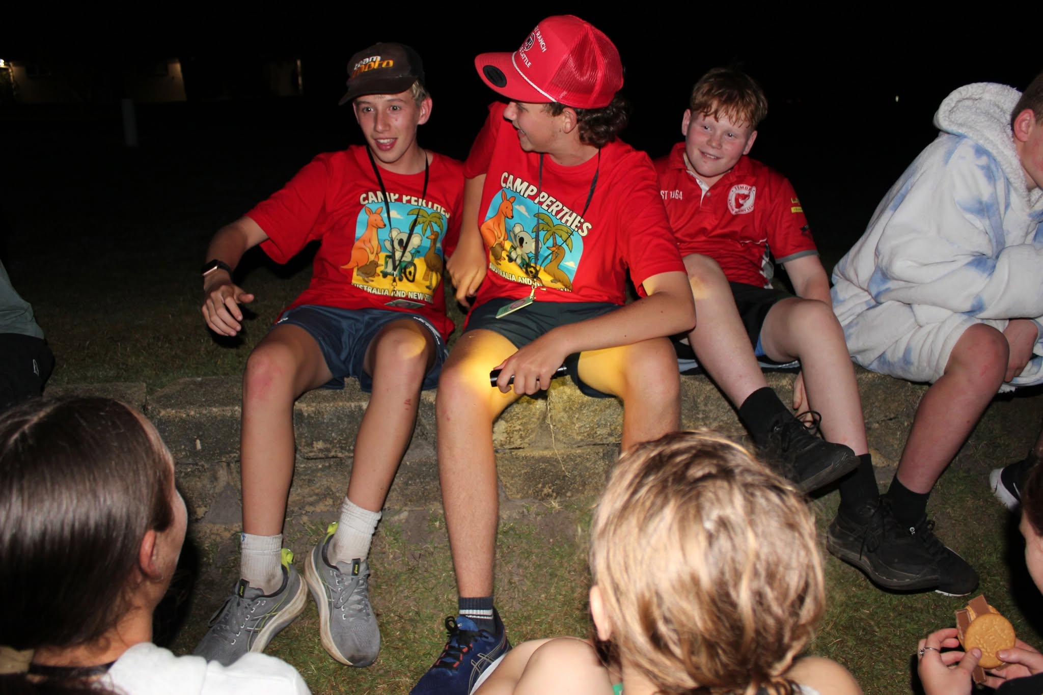 Campers hanging out around the campfire at night