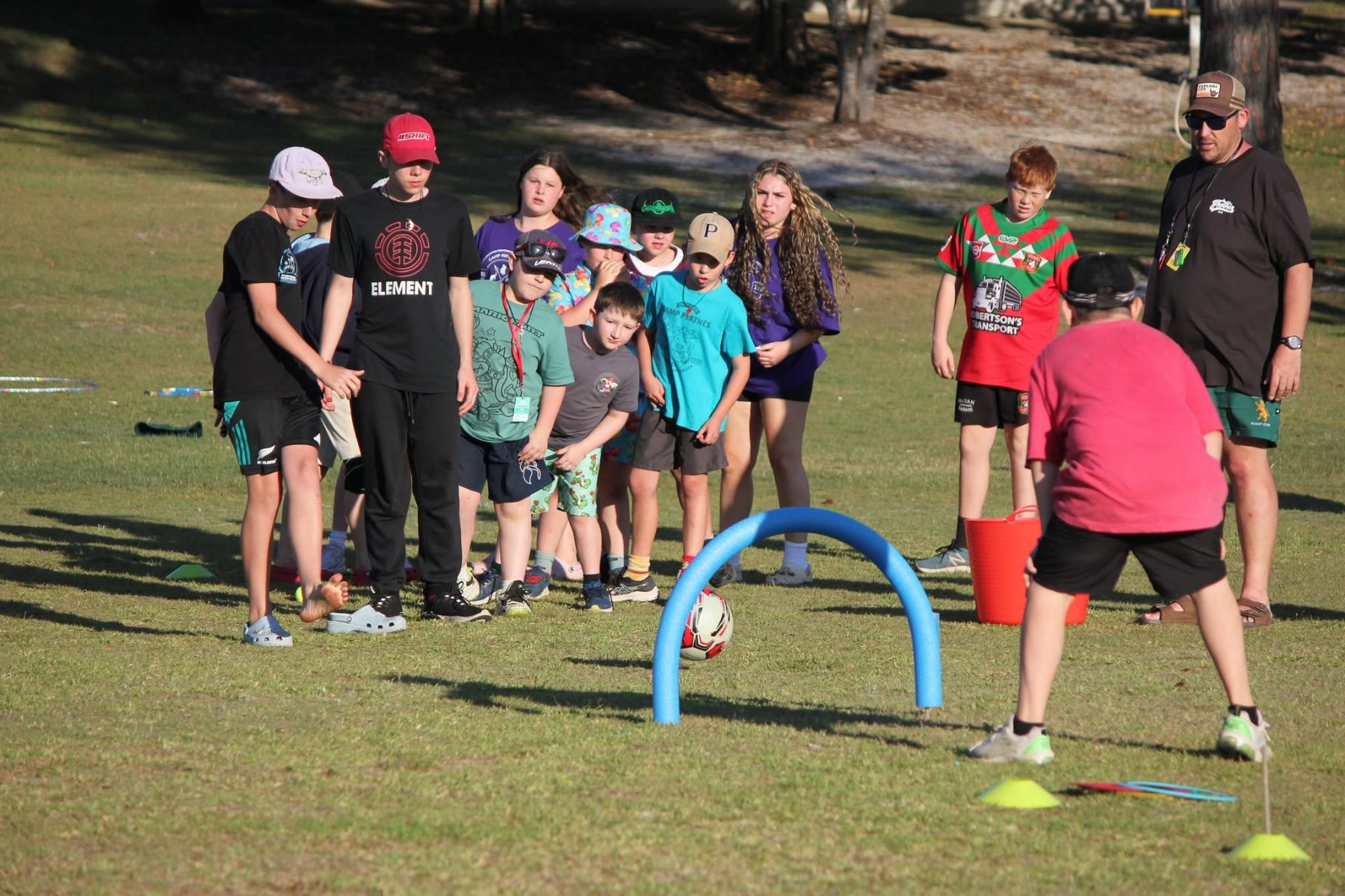 Camp Perthes kids and a counselor playing an outdoor lawn game together on a sunny day