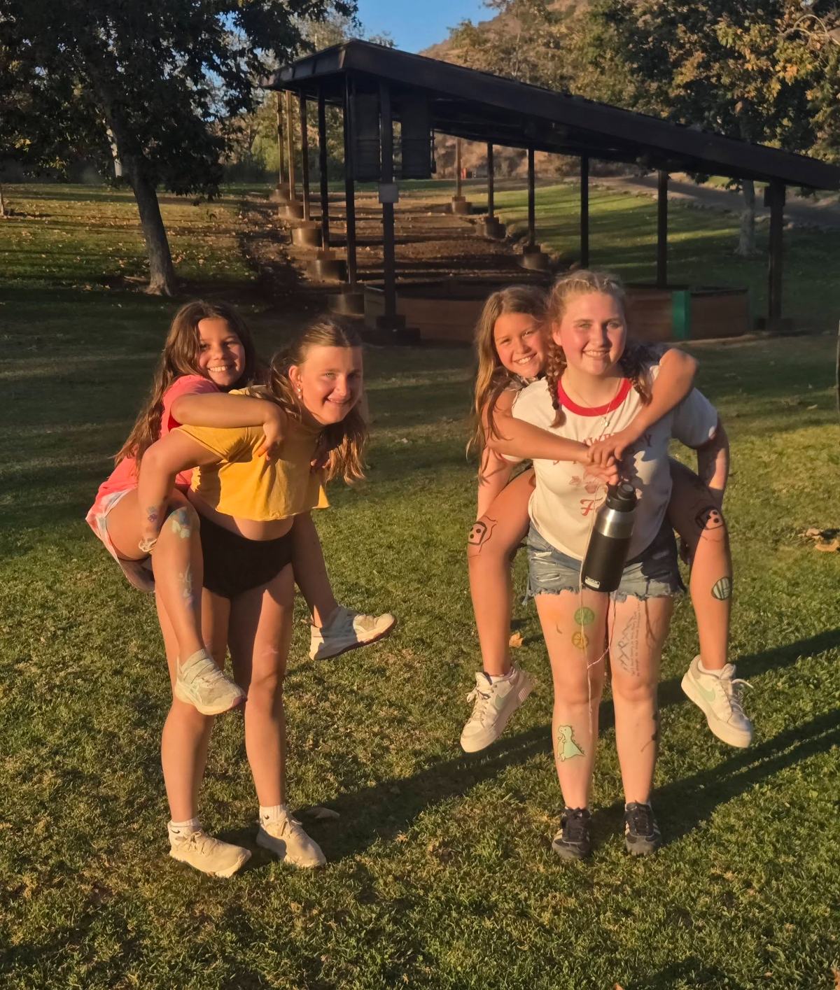 Two campers laughing together, one giving a piggyback