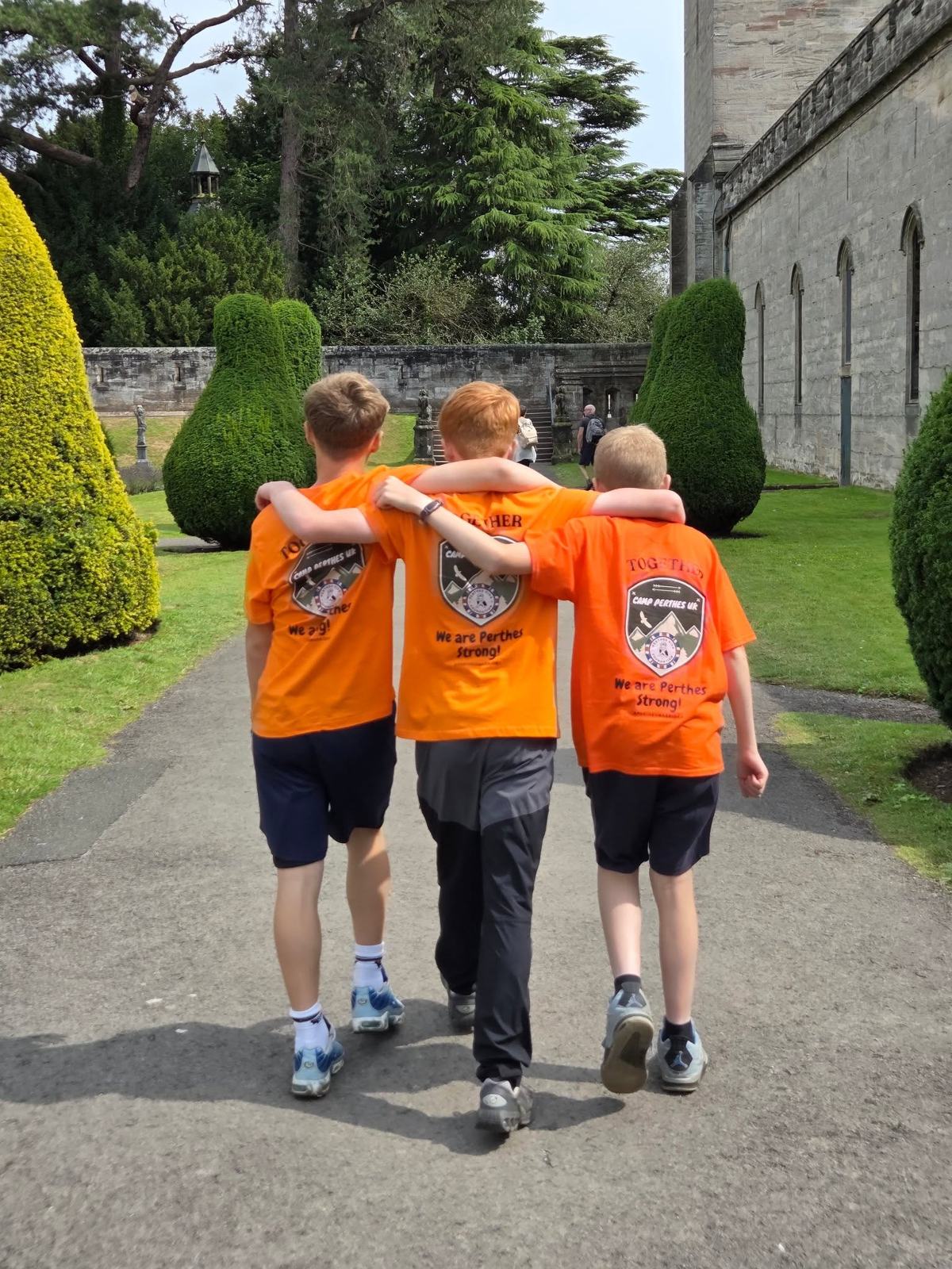 Three young campers walking arm in arm at Camp Perthes UK