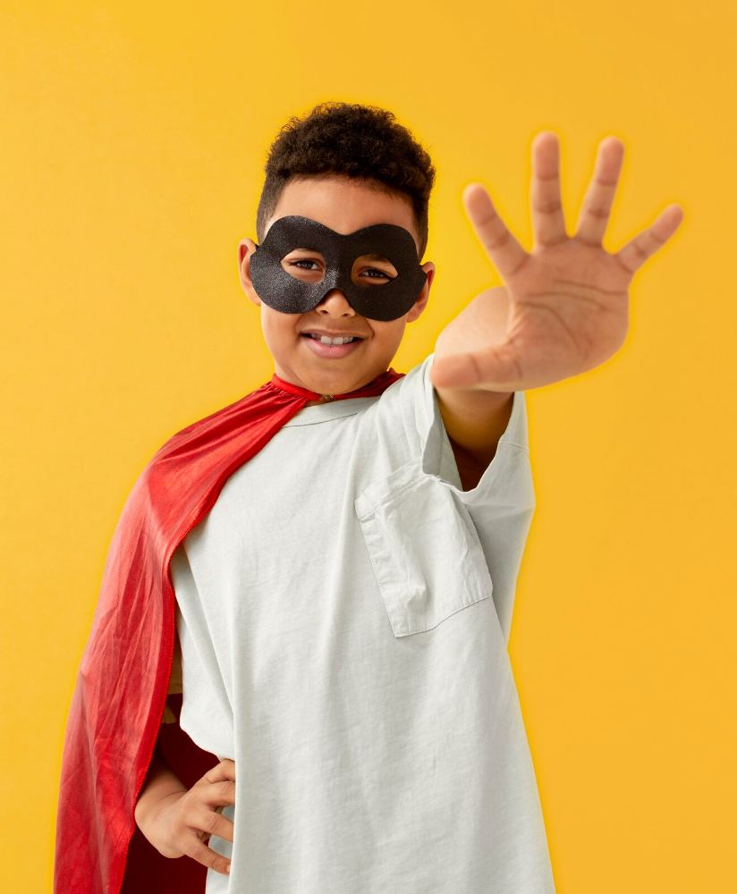 Niño con capa y antifaz de superhéroe